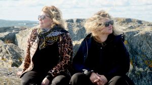 Inger Nilsson och Maria Sid reser ut till sjöss i andra säsongen av En dag i våra liv. Inger Nilsson och maria Sid sitter på klippa med havet i bakgrunden medan deras hår fladdrar i vinden.