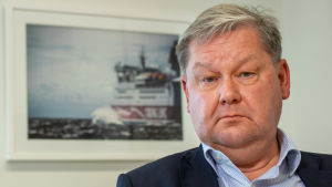 Larmrapporterna om arbetsmiljön på Cinderella berodde huvudsakligen på tre personer som inte jobbar kvar ombord, förklarar Viking Lines vd Jan Hanses. Jan Hanses vd för Viking Line tittar in i kameran. Bilden tagen lite nedifrån och i bakgrunden syns en inramad bild av ett vikinglinefarttyg.