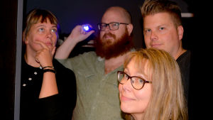 Sandra Anttila, Björn Karlsson, Anders Alanen och Gunilla Celvin här i dörröppningen till det låsbara rummet, Svenska Yles version av rymningsspelet Escape room. Temat i rummet är sanna och falska nyheter. Sandra Anttila, Björn Karlsson, Anders Alanen och Gunilla Celvin.
