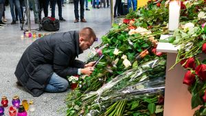 Anhöriga sörjde på flygplatsen i Kiev, planets destination. En man kysser ett porträtt av sin fru, som var flygvärdinna på planet. En man på knä framför en hög med blombuketter.