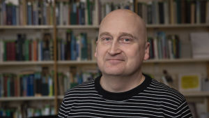 Thomas Karlsson är chefsexpert inom alkoholkonsumtion på Institutet för hälsa och välfärd. En man står framför en bokhylla.