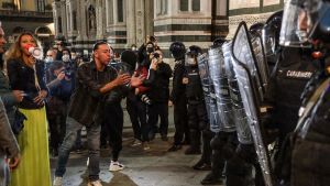 Demonstranter som protesterade mot nya coronarestriktioner i samtal med kravallpolis i Florens. 