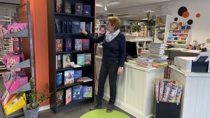 Eriksson står och beundrar bokhandelns nyaste bok. Kristina står och tittar på den nyaste boken i butiken.