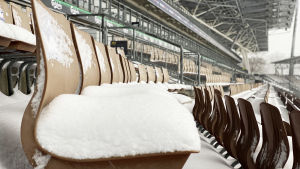 Bollförbundet gör allt för att Finland ska få ta vara på hemmafavören. Snö på en sittplats på Tölö fotbollsstadion.