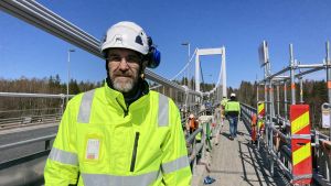 Broingenjör Jari Nikki vid NTM-centralen säger att hängstaget är en väsentlig del av brokonstruktionen. Om den ger efter så fungerar inte bron ordentligt. Läget är därför allvarligt. Jari Nikki, en medelålders man med grått skägg, iförd gul arbetshjälm och neongul arbetsjacka.