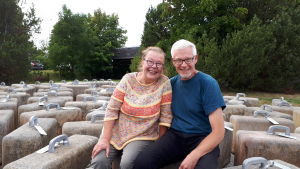 Tiina ja Kimmo Linkama Tiina ja Kimmo Linkama istuvat matkalaukkuilta näyttävien betoteosten päällä