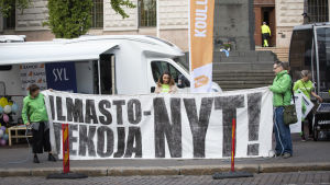 Greenpeace-demonstranter utanför Ständerhuset under regeringsförhandlingarna i maj. Greenpeacen mielenosoitus Säätytalon edessä.