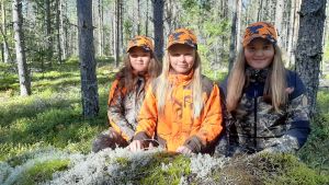 Ina är 10, Nelia 9 och Ada 12 år men har redan varit med på älgjakt i många år. Tre flickor i jaktkläder i skogen.