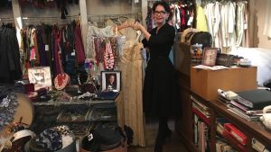 Arja Könönen visar upp en vintageklänning som kunde vara från Pradas höstkollektion. Arja Könönen visar en klänning i sin vintageaffär.