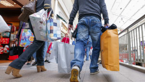 Finländarna har sällan varit så sparsamma som de är nu säger Ralf Sund. Två personer som håller i shoppingkassar under Black Friday.