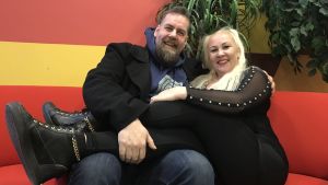 Stan Saanila fick tidigare porrstjärnan och nuvarande sexologen Satu Söderström som gäst i studion. Stan Saanila och Satu Söderström i röd soffa. Satu har benen i Stans knä. I bakgrunden ful randig röd-orange-gul vägg på Yle och en krukväxt.