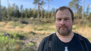Skogshuggare Jari Närvä får avsluta ännu en svettig arbetsdag. Att röja bland vindfällen kräver kunskap och erfarenhet, annars är det farligt. Mansperson står ute bland vindfällen.