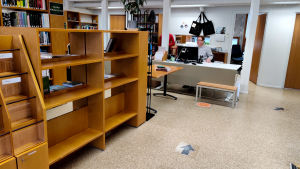 Än så länge är bara en del av biblioteket är öppet för kunderna. Tomma bokhyllor i ett bibliotek.