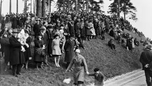 Här firar arbetarna första maj på Tallbacken i Helsingfors år 1930, året innan deras offentliga firande förbjöds. En folksamling på en kulle. Bilden är svartvit och mäniskorna är iklädda gammalmodiga kläder.