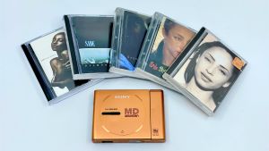 Pöydällä on Sade-artistin levyjä minidisc-muodossa sekä kannettava md-soitin.