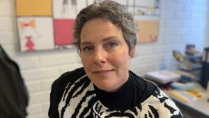 Pamela Backholm är elevhandledare och prorektor för årskurs 7-9 i Vasa övningsskola. Hon oroar sig för att skolfrånvaro blir allt vanligare och pandemin har inte gjort saken bättre. Kvinna med kort frisyr och svartvita kläder sitter i arbetsrum och tittar in i kameran.