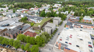 Det nya kulturhuset kanske blir ett hus med grönt grästak (mitt på bilden). Till höger om kulturhuset syns de planerade två flervåningshusen och längst till höger K-Supermarkets takparkering. En visualisering av det nya kulturhuset i Karis stadsbild