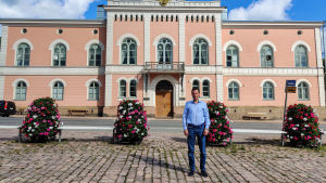 Coronaefterarbetet, stadens ekonomi och samarbetsförhandlingar samt planläggningsfrågor sysselsätter stadsdirektören. En man står på ett torg framför ett rosa stenhus.