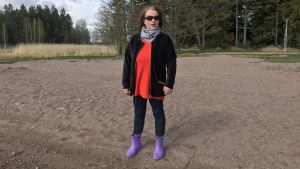 Marlene Walander trivs på stranden oberoende av årstid. Kvinna iklädd solglasögon och stövlar står på en stran en vårdag.