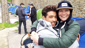 - Ibland kan lite kärlek ge migranterna styrka för resten av dagen, säger Charlotta Hasnouni, volontär från Stockholm. Afghanske Alireza får en kram mitt i misären. En man och en kvinna ger varandra en kram framför en rad tält.