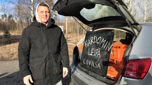Jonas Dufvelin är främst glad över att ingen skadades vid inbrottet. Arkivbild. En man vid sin bils baklucka. I bakluckan finns det en skylt där det står Hardomin leipä Loviisa.