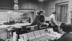 Redaktören Gungerd Wikholm, redaktionschefen Rolf Wessman, ljudteknikern Bo-Erik Ekholm och studiochefen Gösta Sjöholm. Bilden är från år 1985. En radiostudio.