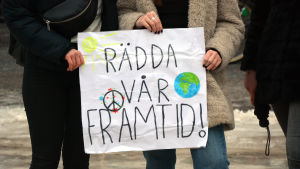Många unga lider av klimatångest idag fast de själva är oskyldiga till utvecklingen. Ett plakat där det står Rädda vår framtid.