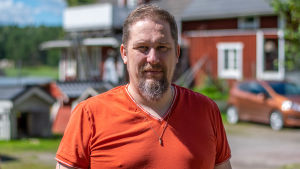 Johan Holmberg på hittedjurshemmet Skeppsdal family i Barösund. en porträttbild på en medelåldersman i orange skjorta.