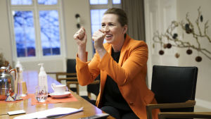 Så här glad var Danmarks statsminister Mette Frederiksen när hon via videolänk fick följa med Danmarks första vaccinering i slutet av december. Statsminister Mette Frederiksen håller upp händerna i hurrarop när hon via videolänk följer med den första vaccinationen i Danmark.