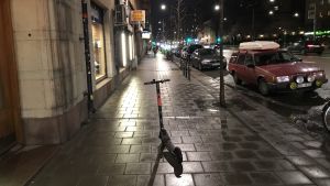 Företagen samlar in elsparkcyklarna under natten och laddar dem. En elsparkcykel står parkerad mitt på trottoaren.