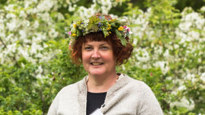Ghita Bodman är också trädgårdsmästare och florist. Kvinna med en midsommarkrans på huvudet.
