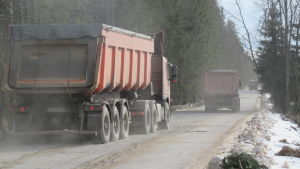 Sandtransporterna fyller vägarna som i framtiden kan trafikeras av sopbilar. Två lastbilar kör på en sandväg.