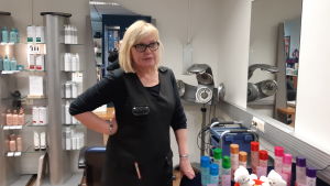 Företagaren Pirjo Colliander i Hiusstudio Pipa berättar att det förr hängde ungdomar kring det lilla köpcentret. Hon återvände till Puumala för 19 år sedan efter att ha verkat i bland annat Helsingfors. Det skulle vara bra om det fanns jobb för de unga och skola för barnen i framtiden, visionerar hon. Barberaren Pirjo Colliander i sin butik i Puumala.