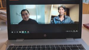Poomin Sithijinda och Chansak Promthong fördriver tiden i karantän genom att läsa, spela spel, titta på tv och sova. Här är de i videointervju med Yle Österbotten. Två män i videosamtal, fotade på datorskärm.