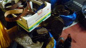 Bälten och boots till Footloose. Läderstövlar/boots i en hög. I en papplåda finns olika läderbälten. Accessoarer till teaterkläder.