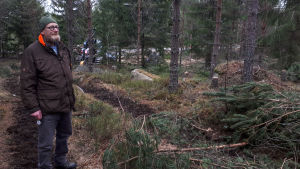 Arnold-Larsen hoppas på en tidig och torr sommar och en bättre vinter nästa år. En man står på en skogsstig i en skog.