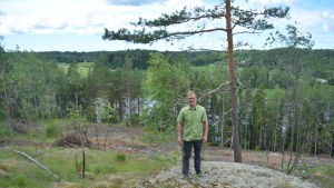 Jukka Henttu framför den röda banan. Om några år har skogen börjat växa upp på kalhygget igen så att rutten går genom skogen. Jukka Henttu från föreningen Flowriders med den nya terrängcyklingsbanan i bakgrunden.