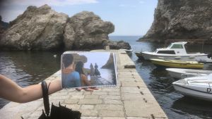 En turistguide visar en bild på en scen från TV-serien Game of Thrones som är inspelad på samma plats som bilden är tagen.