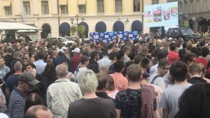 Hundratals personer ville höra och se Jimmie Åkesson i Linköping på onsdagen. Hundratals personer står och lyssnar på ett tal.