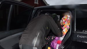 Pappa Patrik Lundberg spänner fast bilbälten. Lillasyster Michelle får också skjuts till dagis. Klockan är nu 7.40 en man, pappa, spänner fast bilbälte på barn i baksätet av en bil