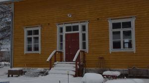 I mörkret är alla katter grå och på den här bilden är det svårt att se att det här huset genomgick en fullständig renovering i slutet av 1990-talet. En gul, gammal trävilla med stentrappa. Huset i hyfsat skick. Vinter och snö.