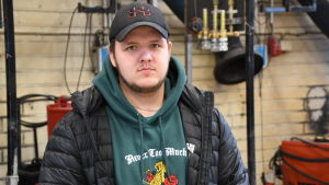 Femtio procent av de intervjuade råkade heta Oscar. Här är Oscar Forsblom som snart är färdig elmontör. En man står i en hall iklädd keps och jacka.