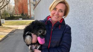 Hunduppfödare Kaisa Metteri-Gold med hundvalpen Kalla. En kvinna med en hundvalp i famnen.