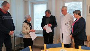 Birgitta Nordström var med och överräckte ett brev till sjukhusets representanter i mars. En man och en kvinna överräcker ett papper till tre personer, två män och en kvinna. Den ena mottagande mannen i vit läkarrock.