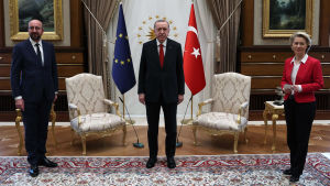 Europeiska rådets ordförande Charles Michel och kommissionens ordförande Ursula von der Leyen tillsammans med Turkiets president Erdogan. I bakgrunden syns EU:s och Turkiets flaggor, samt två stolar.