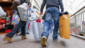 Black Friday är inte längre en konsumtionsfest som ordnas bara en dag. Två personer som håller i shoppingkassar under Black Friday.