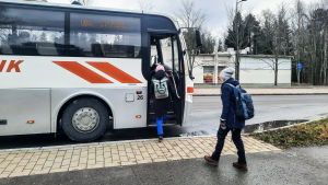 Också skolbussar måste snart köra fossilfritt. Två passagerare stiger på en buss.