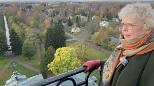 Ann-Katrin Svenns beundrar den storslagna vyn från den tidigare hovrättens tak. En kvinna med halsduk står vid ett räcke i ett torn och blickar ut över Korsholms skogar
