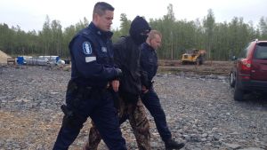 Polisen har blivit van med demonstranter vid kärnkraftsbygget i Pyhäjoki. Den här bilden togs i juni ifjol. Aktivist förs bort av polis.
