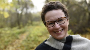 Camilla Brunells väg till prästyrket har varit lång och svår. Kvinna med glasögon ler mot kameran